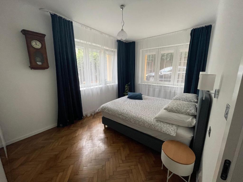 um quarto com uma cama e um relógio na parede em Woodland Apartment em Gdynia