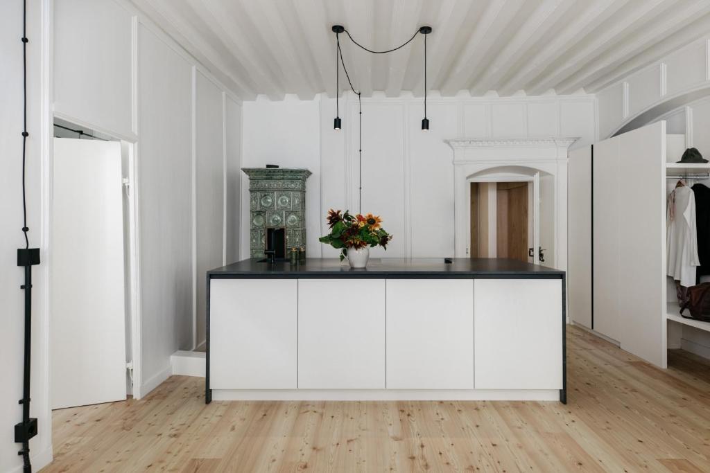 a white room with a counter with flowers on it at Ida - historic town apartments in Vipiteno