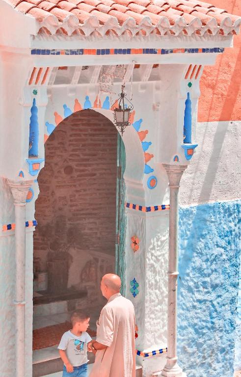 a man and a boy standing under an archway at RIAD LA SANTA in Chefchaouen