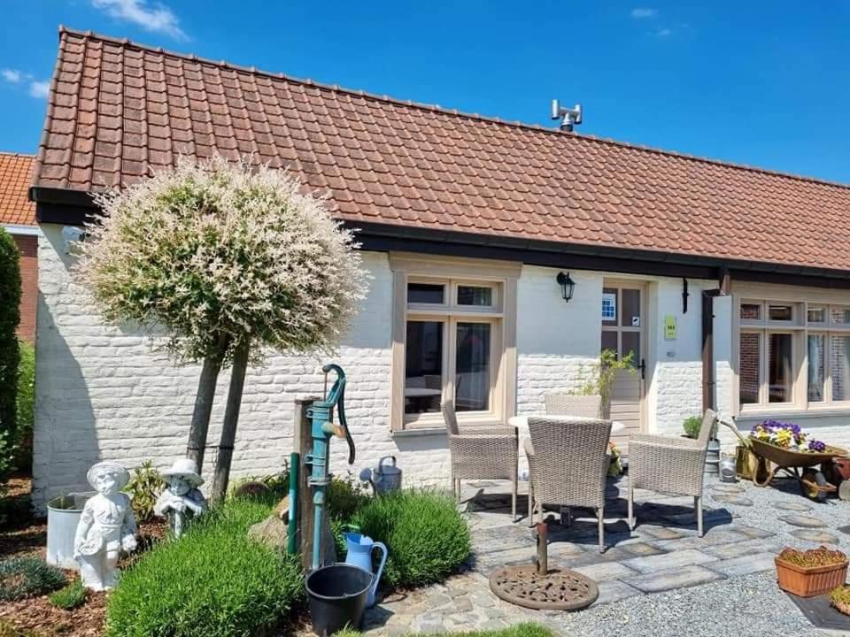 um chalé com uma mesa e cadeiras em frente em DHofstede vakantiewoning em Oudenaarde