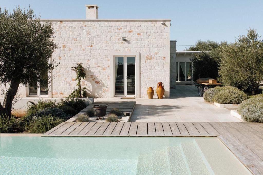 una piscina di fronte a una casa con due cani di Trullo Piccolo ad Alberobello