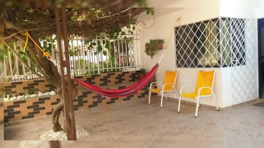 a room with two chairs and a hammock at Cabaña Midas Rodadero in Santa Marta