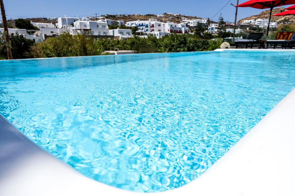 a large blue swimming pool with a view of buildings at Casa Grande Hotel in Platis Yialos Mykonos