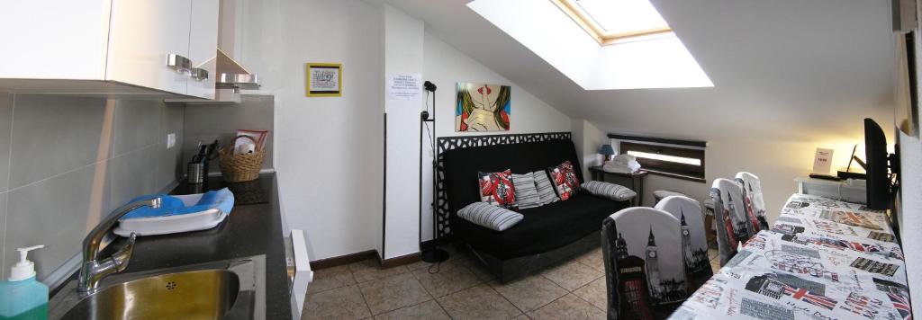 sala de estar con sofá y lavamanos en LOS ATICOS, en Santander
