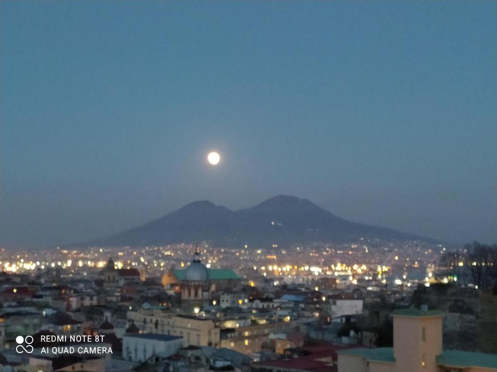 a moon rising over a city at night at Casa vacanze Maison Zio Bruno A' Scalinatella in Naples