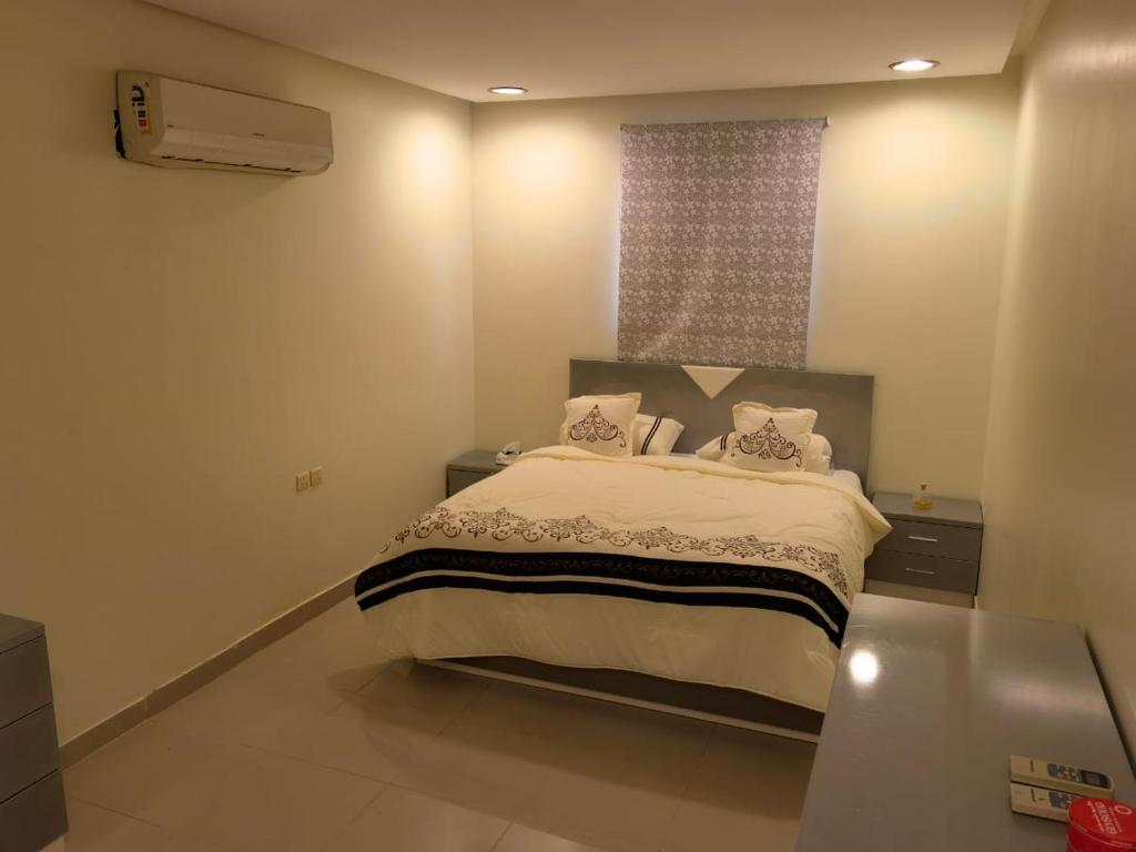 Schlafzimmer mit einem großen Bett und einem Fenster in der Unterkunft نزل الفيحاء in Riad