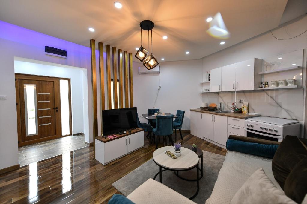 a living room with a couch and a table and a kitchen at Apartman 3M Lux in Vrnjačka Banja