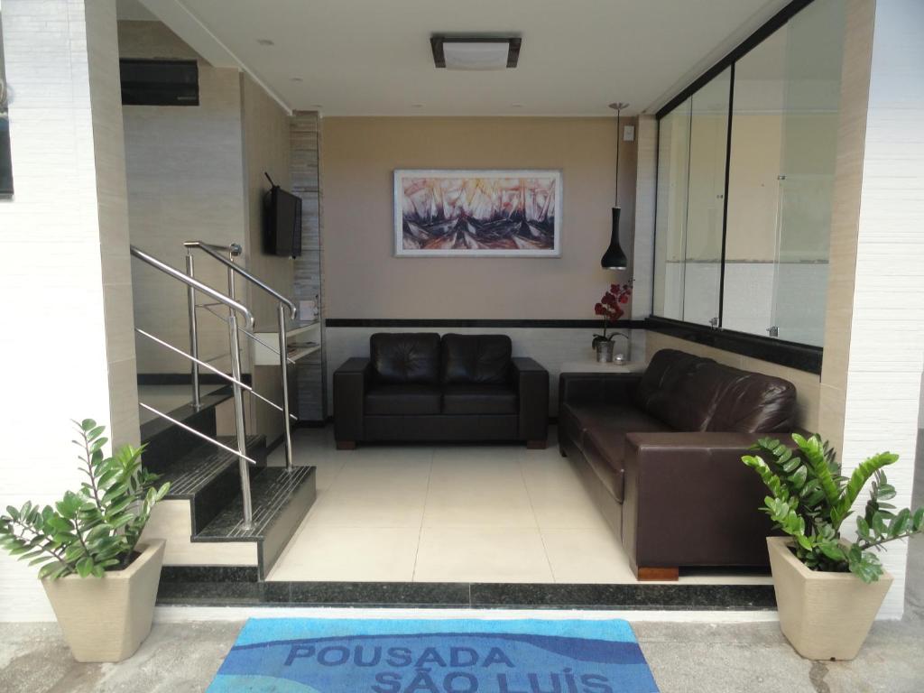 a living room with two couches and a staircase at Pousada São Luiz in Aracaju