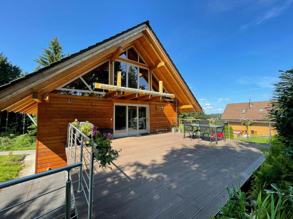 a house with a wooden deck with a balcony at Apartments in Blockhaus im Wald in Siegsdorf