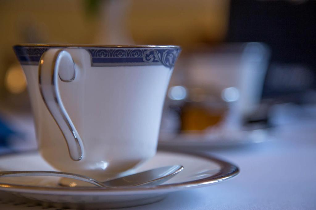 a cup of coffee sitting on a table with a spoon at Balincourt in Bournemouth
