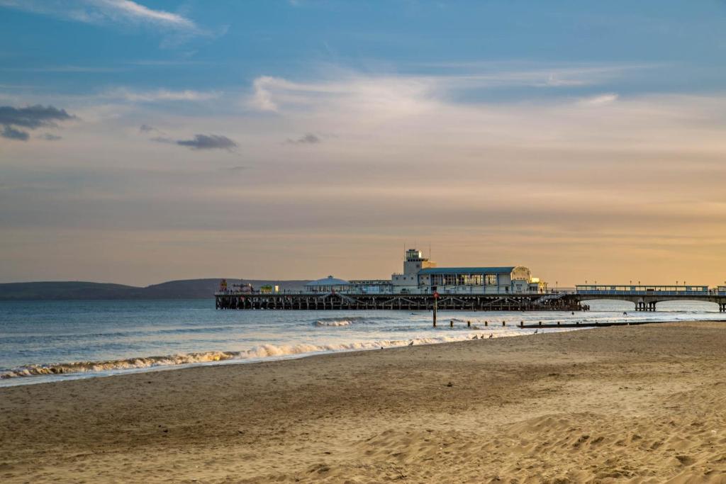 a pier on the beach with the ocean and a sandy beach at Balincourt in Bournemouth