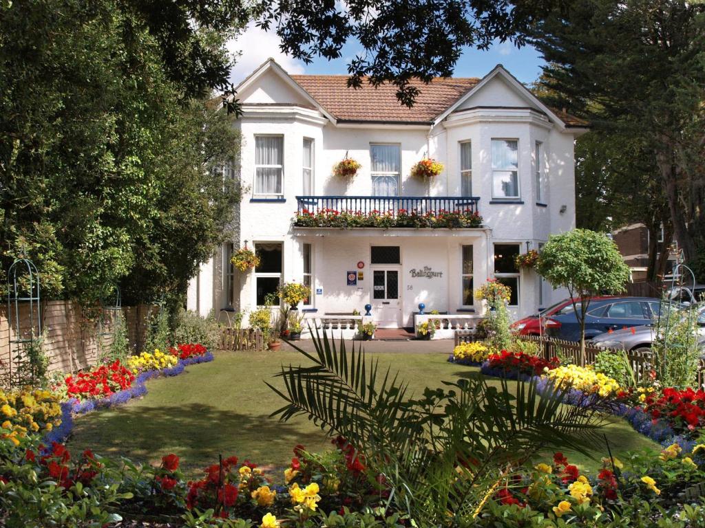 伯恩茅斯的住宿－巴林科特酒店，前面有鲜花的白色房子