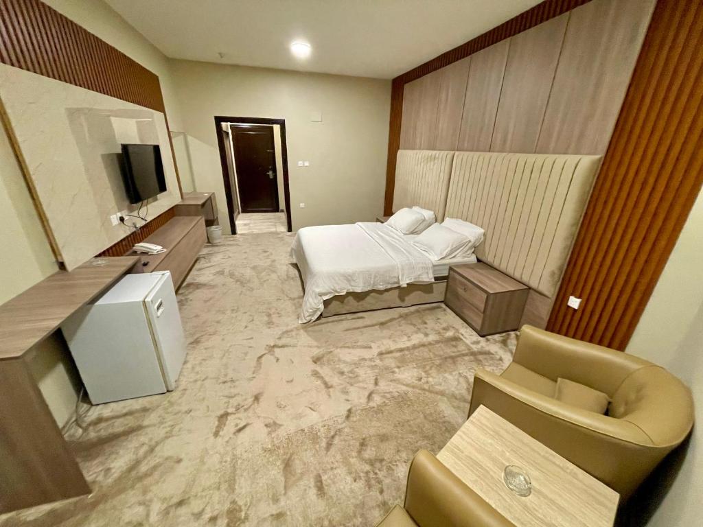 ein Hotelzimmer mit einem Bett und einem TV in der Unterkunft Relax Day Hotel in Tabuk