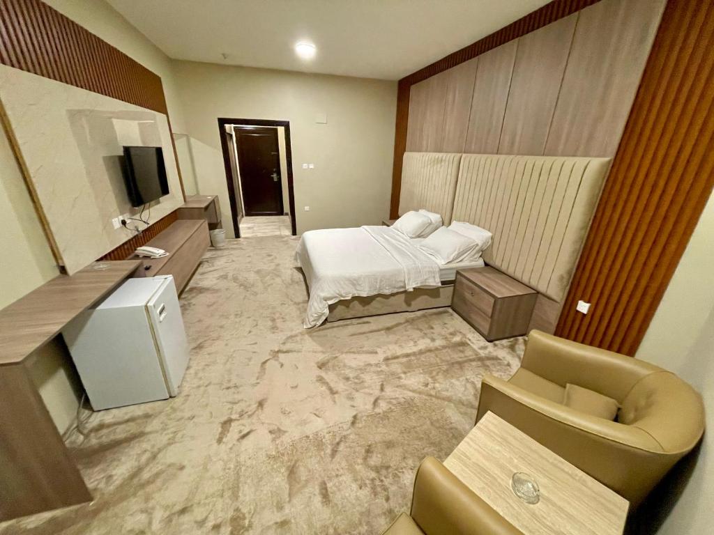 um quarto de hotel com uma cama e uma televisão em Relax Day Hotel em Tabuk