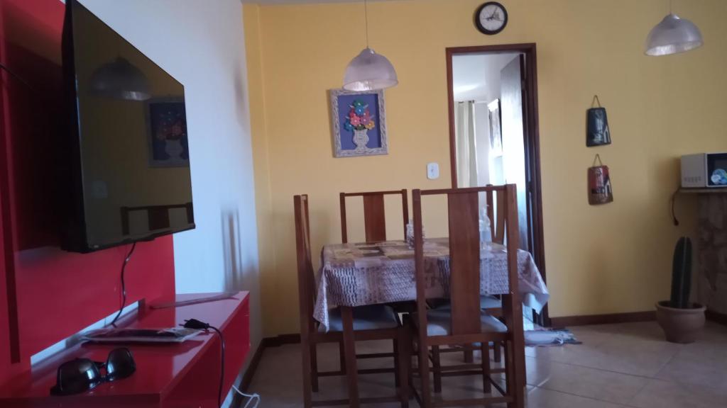 a dining room with a table and a tv at Kitnet Aurora in Miguel Pereira