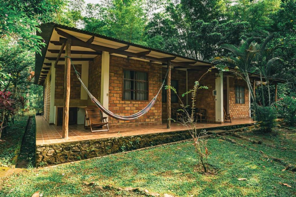 a small house with a hammock in front of it at Huingos Eco Lodge in Tarapoto
