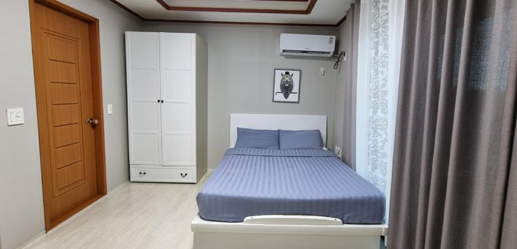 ein kleines Schlafzimmer mit einem Bett in der Ecke eines Zimmers in der Unterkunft Toursketch Pension in Seogwipo