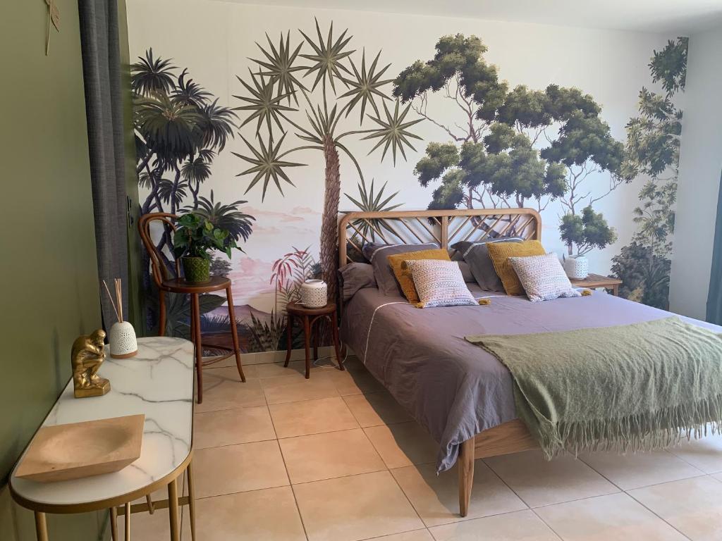 1 dormitorio con 1 cama con plantas en la pared en Chambre en Drôme Tropicale en Chabeuil