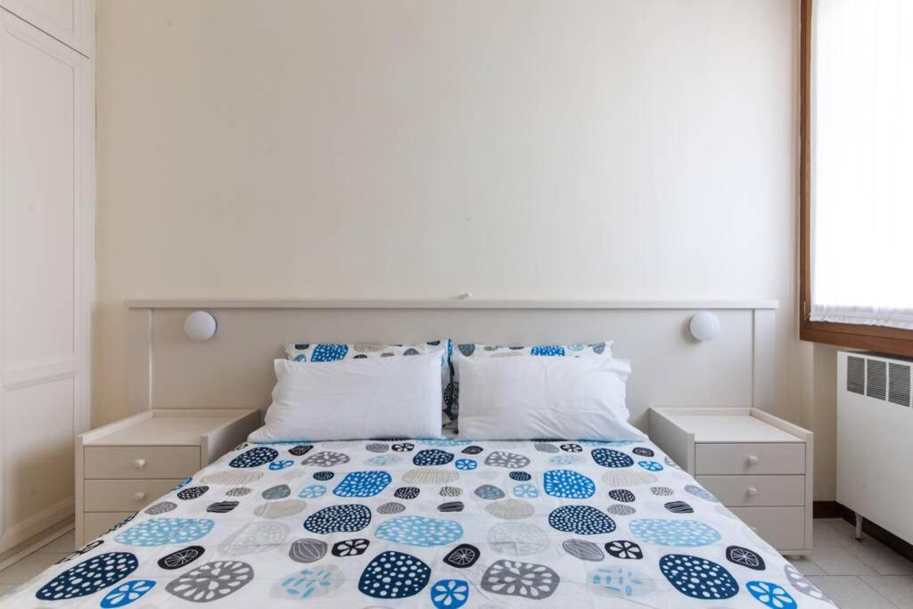 - une chambre avec un lit et une couette bleue et blanche dans l'établissement Residence RivaAzzurra Appartamento, à Milano Marittima