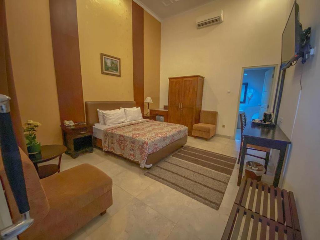 ジョグジャカルタにあるル クラサック ブティック ホテルのベッドとソファ付きのホテルルーム