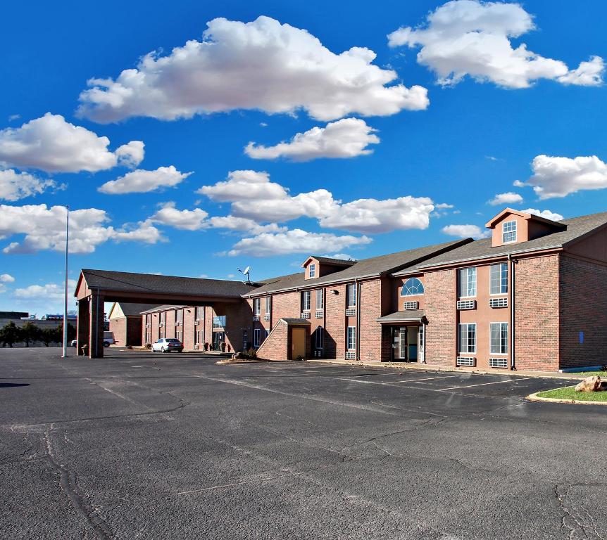 an empty parking lot in front of a brick building at Coratel Inn & Suites by Jasper Newton in Newton