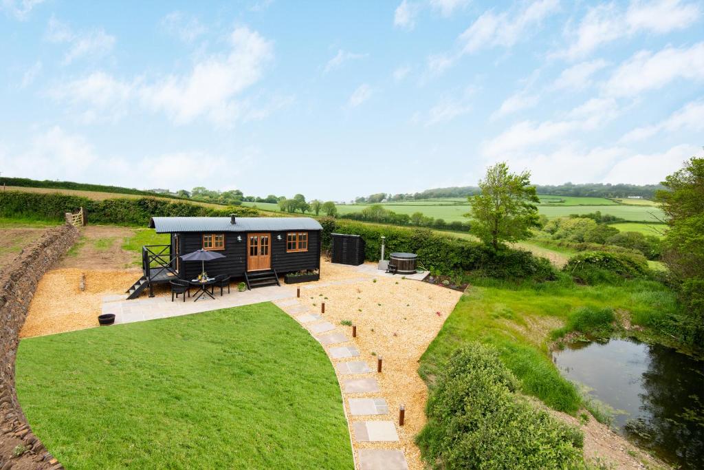 a tiny house in the middle of a field at Daisy Park Shepherds Hut in Looe