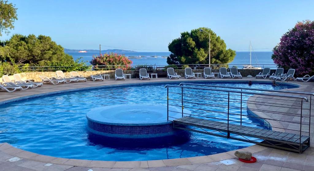 una gran piscina con tumbonas y sillas en AJACCIO les iles sanguinaires en Ajaccio