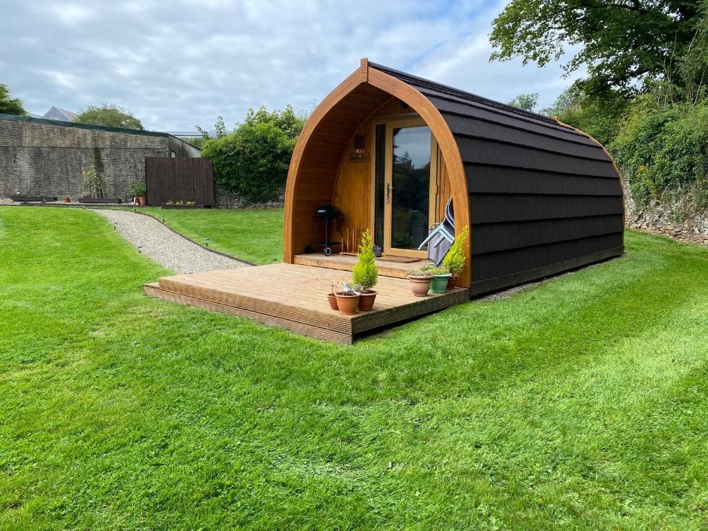 un pequeño cobertizo con una terraza en el césped en Garden Cottage Glamping Pod en Boncath