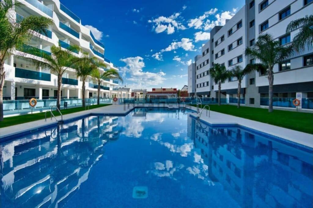 una gran piscina en medio de un edificio en Lovely apartment with pool in Fuengirola Mijas Costa, en Málaga