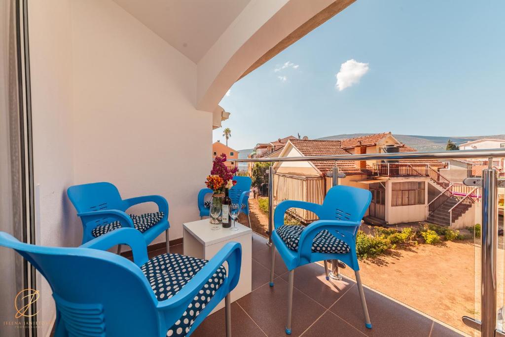 uma varanda com cadeiras azuis e vista em Family blue apartman Montenegro em Baošići