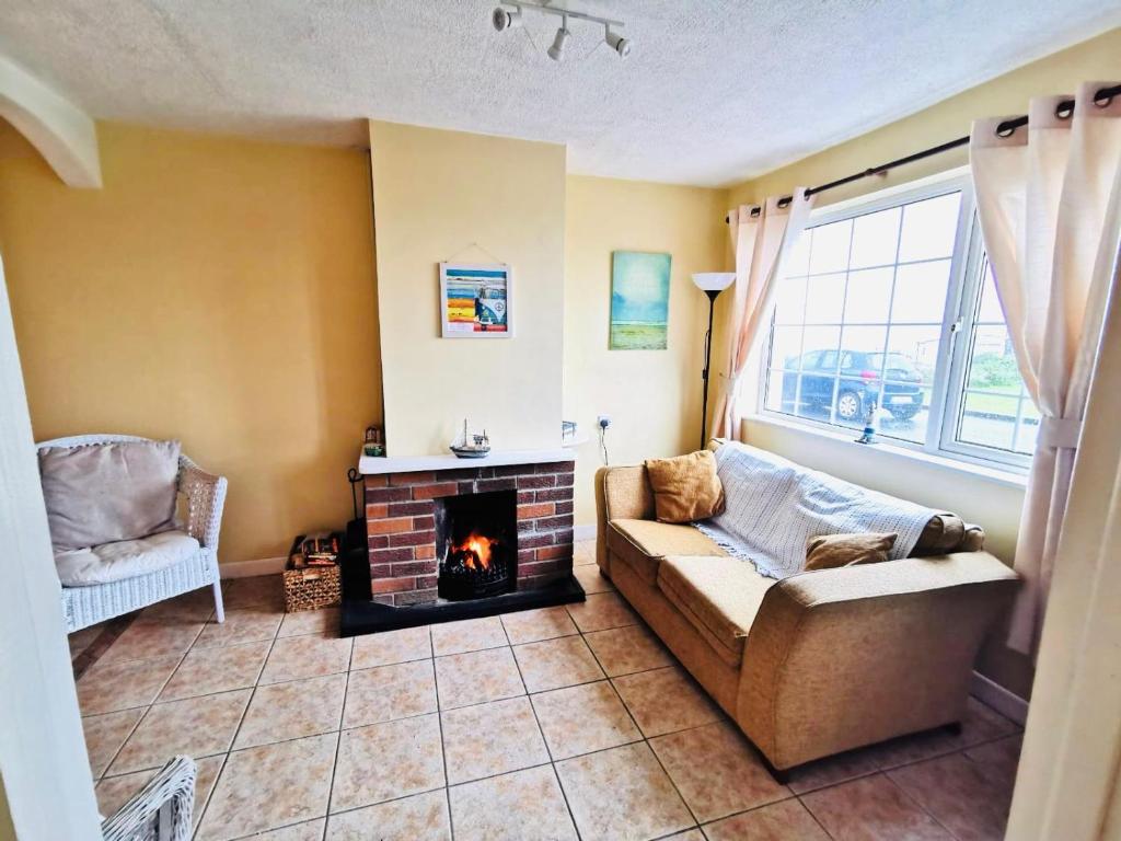- un salon avec un canapé et une cheminée dans l'établissement Rossnowlagh Creek Chalet 5, à Rossnowlagh