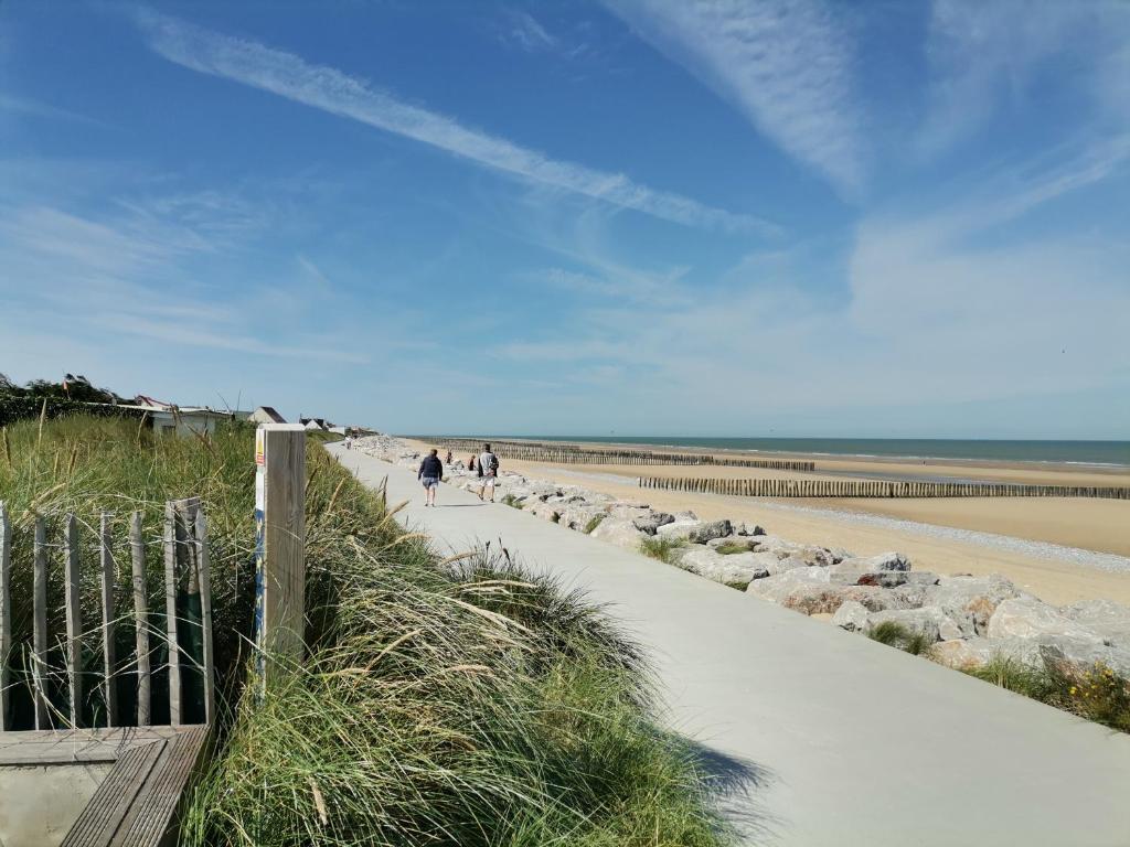 een groep mensen die langs een zandstrand lopen bij Le vent du large in Sangatte