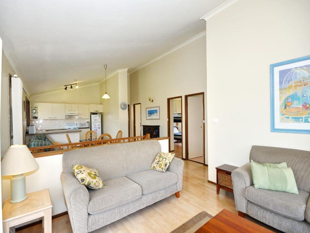 a living room with two couches and a kitchen at Pet Friendly on Pelican Close to Myall River in Hawks Nest