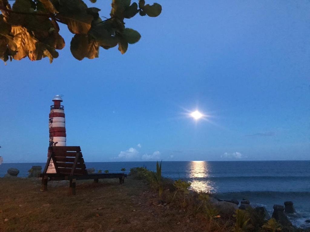 a lighthouse sitting on the beach next to the ocean at Bridge12th B&amp;B in Yanliau