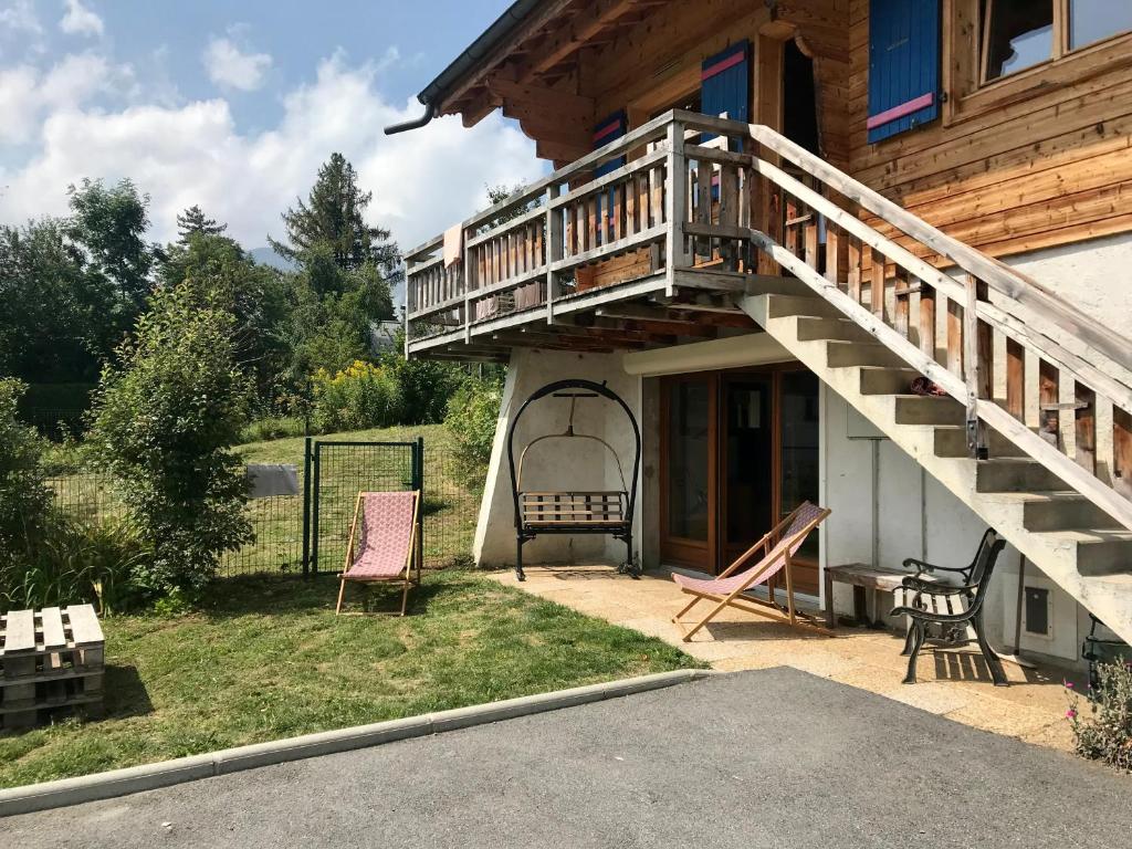 eine Veranda eines Hauses mit einer Holztreppe in der Unterkunft Chalet Cyclamens- 65m2 plein centre des Carroz - WIFI & parking! in Les Carroz d'Araches