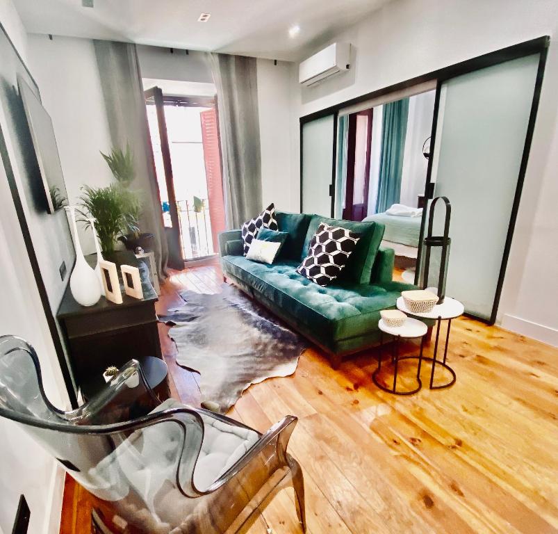 een woonkamer met een groene bank en een tafel bij Apartamento de diseño en Malasaña junto a Gran Vía in Madrid