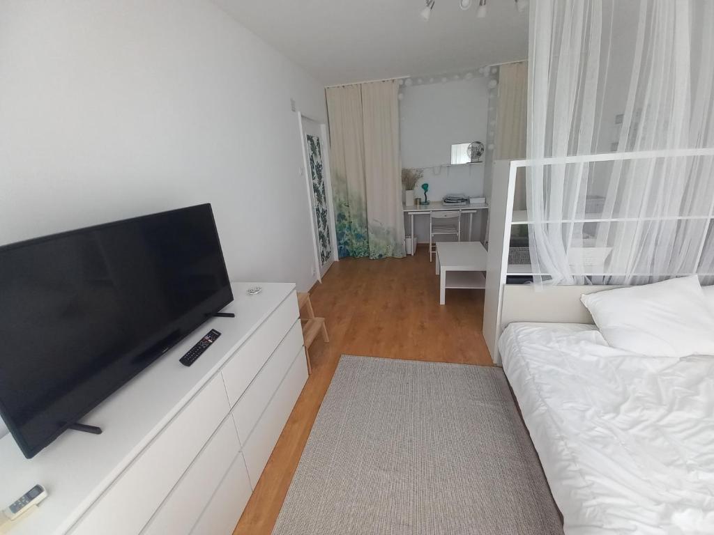 Il comprend un salon blanc doté d'une télévision à écran plat. dans l'établissement Garsoniera Comfort, à Bucarest