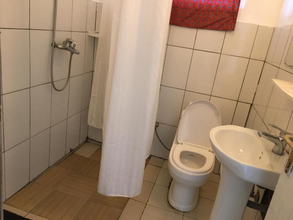 un baño con inodoro y lavabo en Judith Home FIKA CAFE, en Kigali