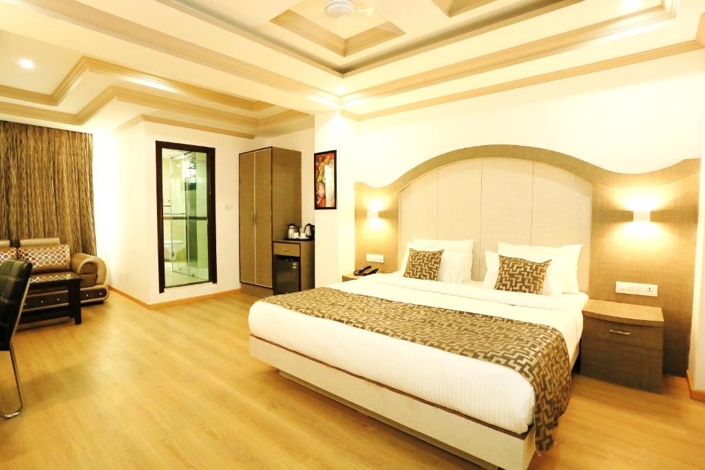 een hotelkamer met een bed en een stoel bij Crown Plaza Residency in Srinagar