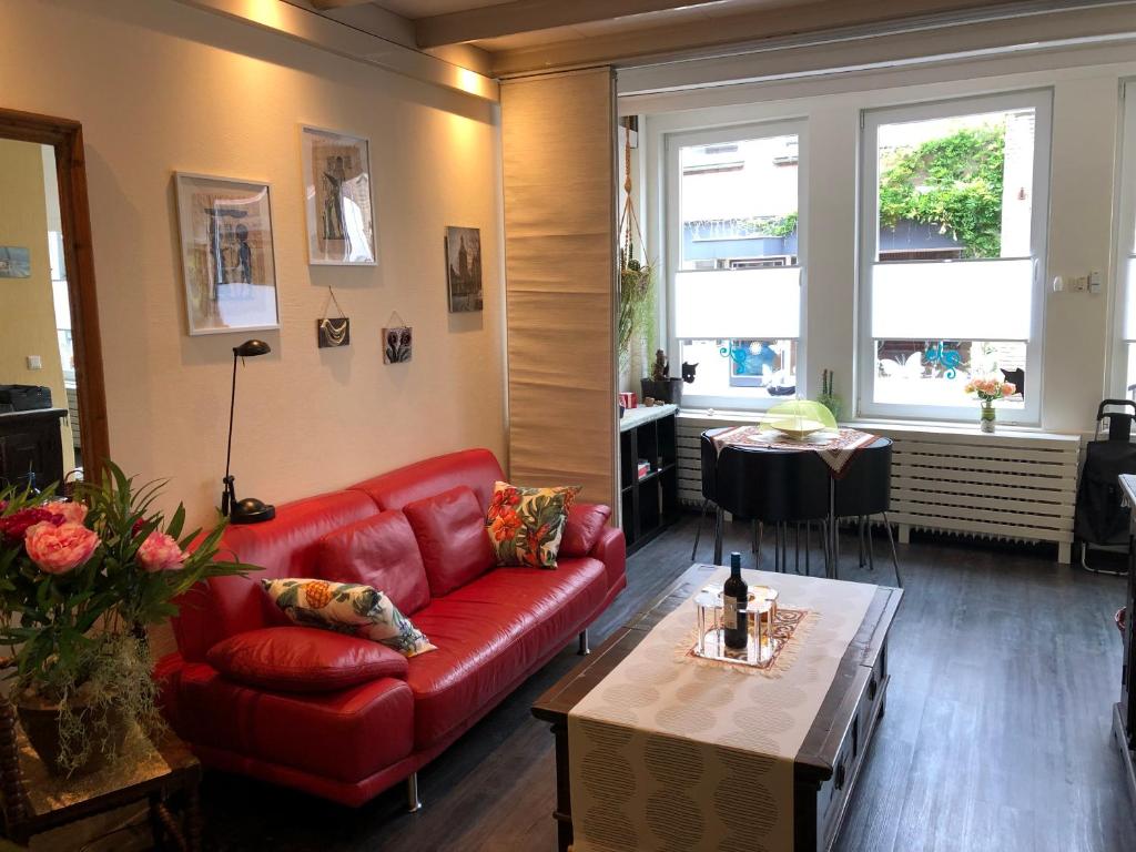 - un salon avec un canapé rouge et une table dans l'établissement Centrum Meppel, à Meppel