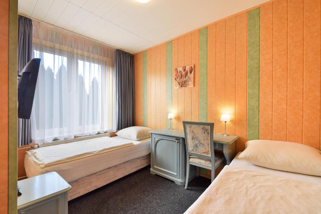 a hotel room with two beds and a window at Pokoje Gościnne Stara Masarnia in Chojna