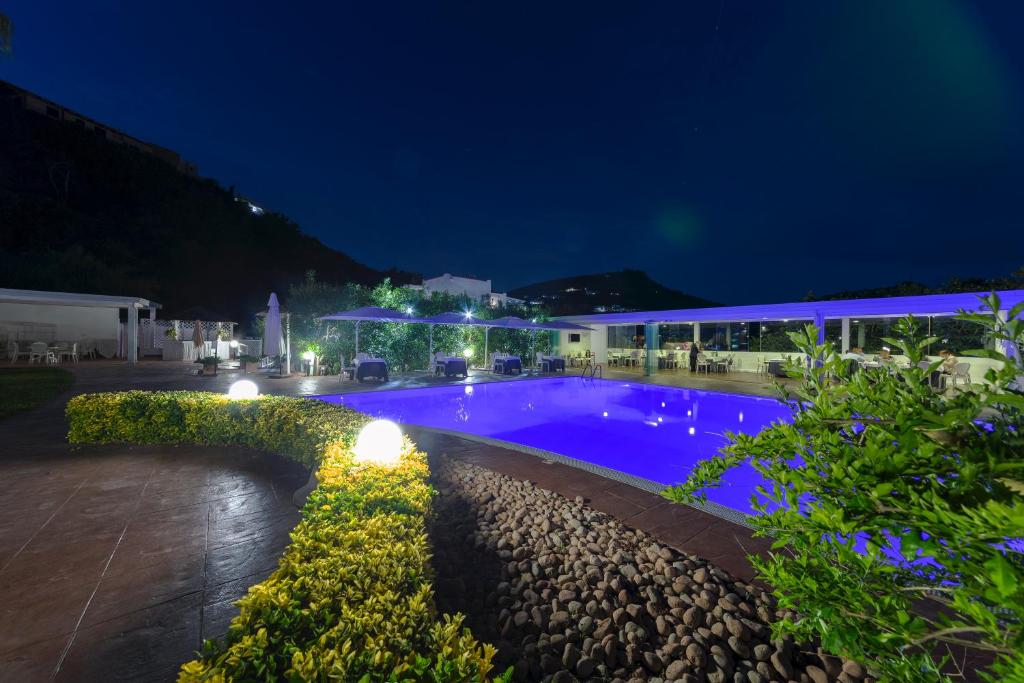 ein Schwimmbad in der Nacht mit Lichtern in der Unterkunft Agave Hotel in Pozzuoli