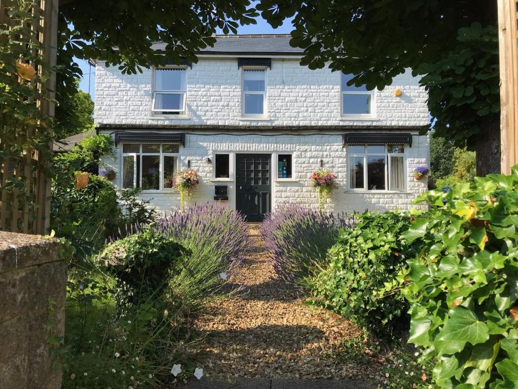 uma casa com flores roxas em frente em The White House em Milton Keynes