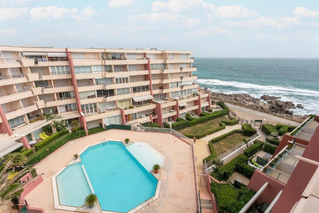 - une vue aérienne sur un hôtel avec une piscine et l'océan dans l'établissement Appartement T3 terrasse vue sur mer, piscine, parking, wifi et clim, à Sète