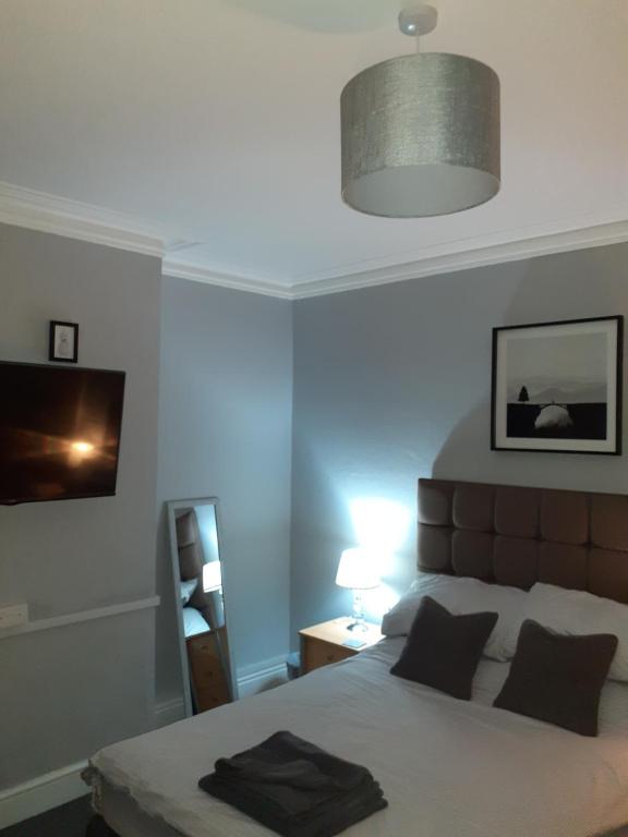 a bedroom with a bed and a lamp and a light at Caversham Lodge in Reading