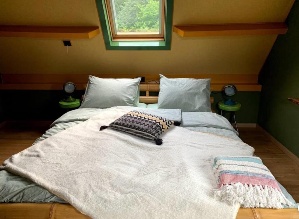 a large bed in a bedroom with two pillows on it at Oeroeboeroe in Roderesch