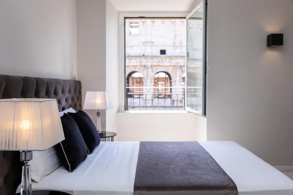 ein Schlafzimmer mit einem Bett und einem großen Fenster in der Unterkunft Amazing Colosseo in Rom