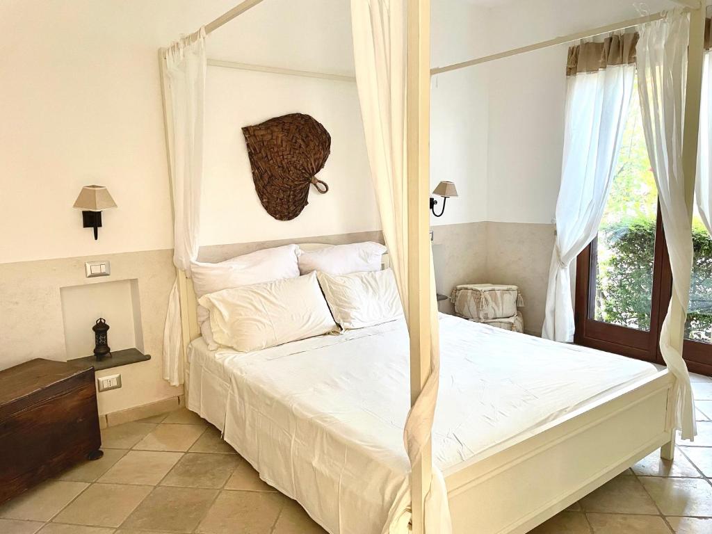 a bedroom with a canopy bed and a window at Villa Maris Capo Vaticano in Capo Vaticano