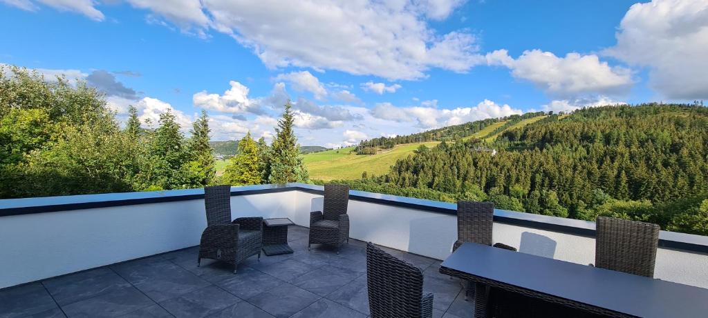 balkon z krzesłami i widokiem na góry w obiekcie Upland View w mieście Willingen