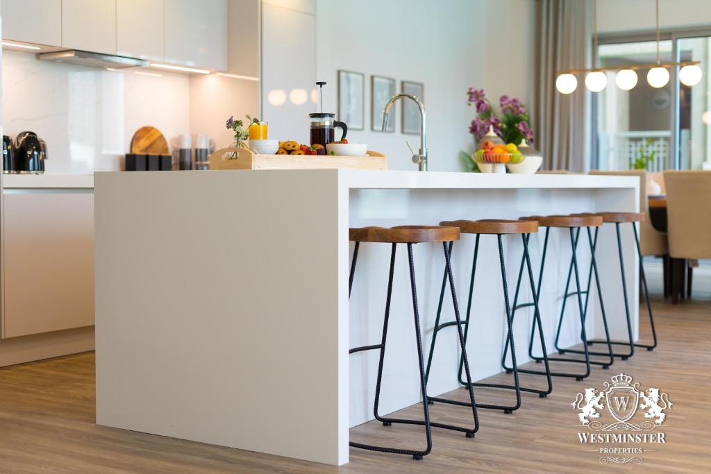 a kitchen with a counter with stools under it at Westminster Burj Residences in Dubai